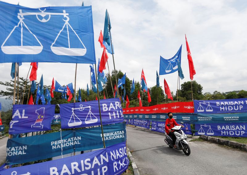 &copy; Reuters. FILE PHOTO: A motorcyclist rides past the party flags and banners during the campaign period of Malaysia's general election in Ipoh, Perak, Malaysia November 6, 2022. REUTERS/Hasnoor Hussain