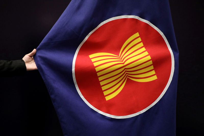 &copy; Reuters. Photo d'archives: Un ouvrier ajuste un drapeau de l'ANASE dans une salle de réunion à Kuala Lumpur, en Malaisie. /Photo prise le 28 octobre 2021/REUTERS/Lim Huey Teng