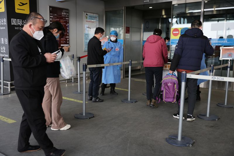 &copy; Reuters. Dei viaggiatori entrano in una sala del terminal del Beijing Capital International Airport a Pechino, Cina, 23 marzo 2022. REUTERS/Tingshu Wang/Files