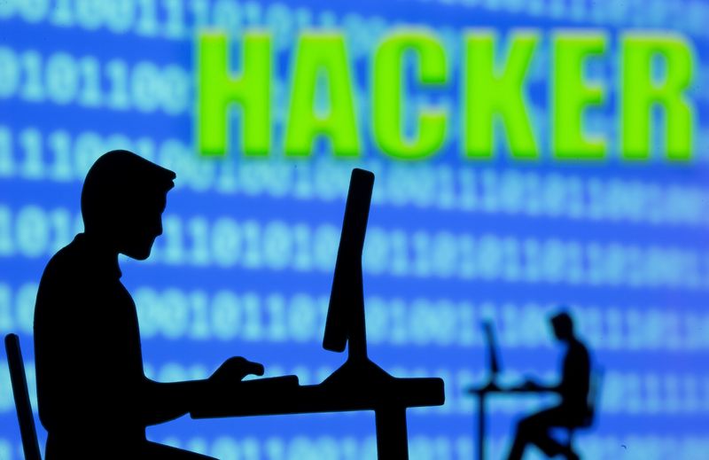 &copy; Reuters. Un modèle imprimé en 3D d'hommes travaillant sur des ordinateurs est vu devant un code binaire affiché et les mots "Hacker" dans cette illustration prise. /Photo prise le 5 juillet 2021/REUTERS/Dado Ruvic