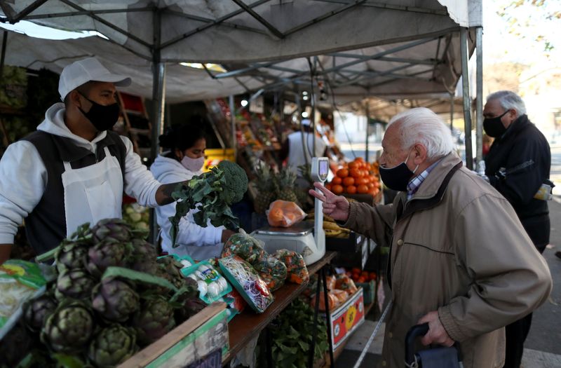 &copy; Reuters. FILE PHOTO: A customer speaks with a vegetable seller at a greengrocery store in a street market, in Buenos Aires, Argentina June 15, 2021. Picture taken June 15, 2021. REUTERS/Agustin Marcarian/File Photo