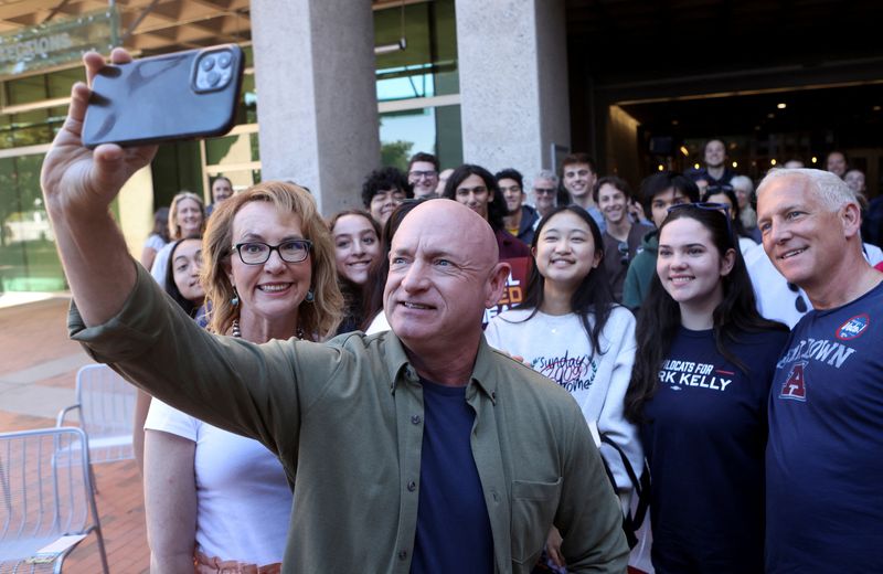 © Reuters. FILE PHOTO: U.S. Senator Mark Kelly and his wife Gabby Giffords take a selfie at a campaign event ahead of the November 8, 2022 U.S. midterm elections in Tucson, Arizona, U.S., November 6, 2022. REUTERS/Jim Urquhart