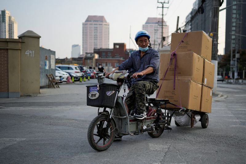 &copy; Reuters. FILE PHOTO: A delivery worker wearing a protective mask rides an electric scooter across a street ahead of Alibaba's Singles' Day shopping festival, following a coronavirus disease (COVID-19) outbreak in Shanghai, China, November 10, 2022. REUTERS/Aly Son