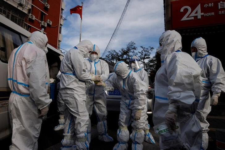 &copy; Reuters. Trabajadores de prevención pandémica vestidos con trajes protectores preparándose para entrar en un complejo de departamentos en confinamiento por un brote de COVID-19 en Pekín, China. 12 noviembre 2022. REUTERS/Thomas Peter