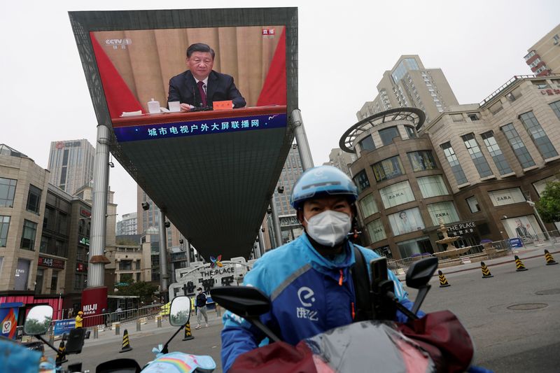 &copy; Reuters. Motociclista diante de telão com presidente Xi em Pequim
10/05/2022
REUTERS/Tingshu Wang