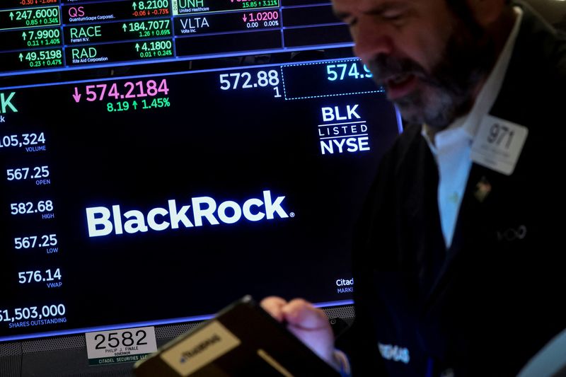 © Reuters. FILE PHOTO: A trader works as a screen displays the trading information for BlackRock on the floor of the New York Stock Exchange (NYSE) in New York City, U.S., October 14, 2022. REUTERS/Brendan McDermid