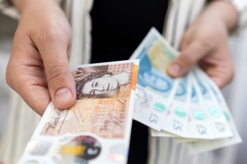 &copy; Reuters. FILE PHOTO: Woman holds British Pound banknotes in this illustration taken May 30, 2022. REUTERS/Dado Ruvic/Illustration