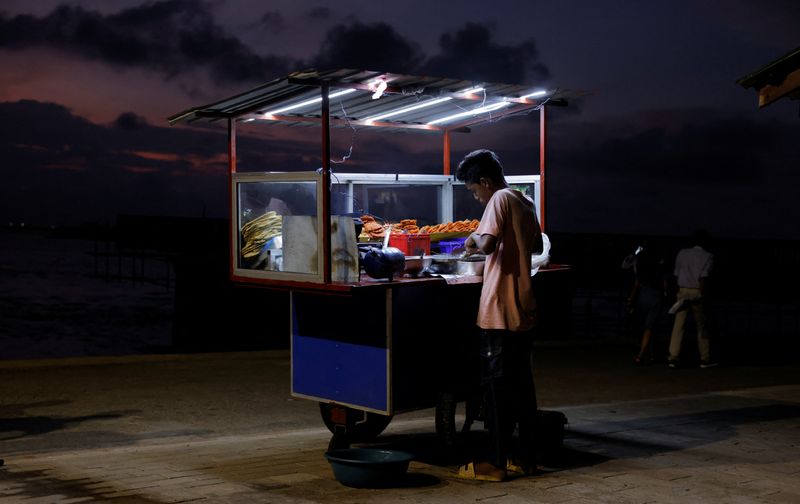 &copy; Reuters. FILE PHOTO: A vendor cooks food for customers in his food cart at Galle Face Green, amid the country's economic crisis, in Colombo, Sri Lanka, October 31, 2022. REUTERS/ Dinuka Liyanawatte/File Photo