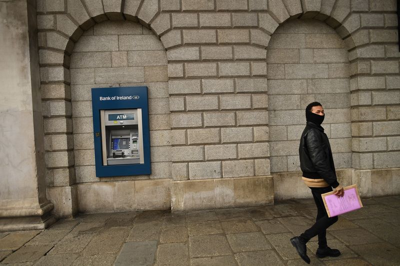 &copy; Reuters. FILE PHOTO: A man walks past a Bank of Ireland ATM outside a branch of the Bank of Ireland in Dublin, Ireland, March 1, 2021. REUTERS/Clodagh Kilcoyne