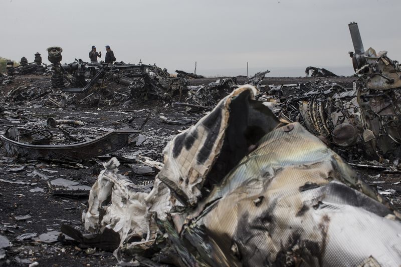 © Reuters. People talk near the remains of fuselage of the downed Malaysia Airlines flight MH17, near the village of Hrabove (Grabovo) in Donetsk region, eastern Ukraine September 9, 2014. REUTERS/Marko Djurica  