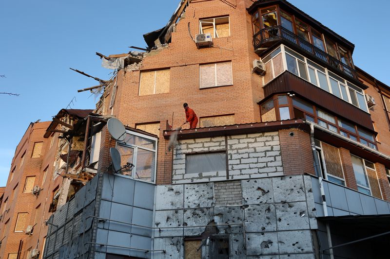© Reuters. A man cleans rubble at a damaged residential building, as Russia's attack on Ukraine continues, in Mykolaiv, Ukraine, November 14, 2022. REUTERS/Murad Sezer