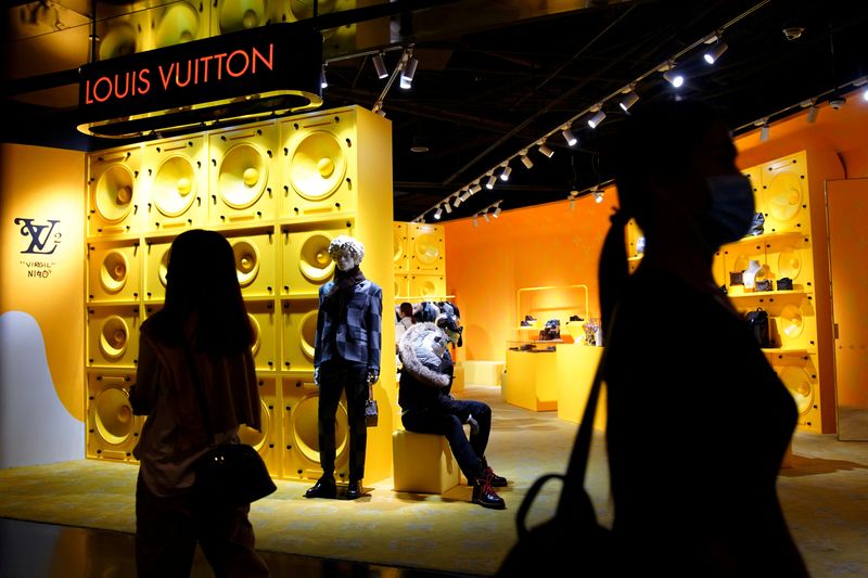 &copy; Reuters. I clienti con indosso delle mascherine a causa della epidemia di Covid-19 davanti a un negozio del marchio di lusso francese Louis Vuitton, a Pechino, Cina, 19 settembre 2020. REUTERS/Tingshu Wang/File Photo/File Photo
