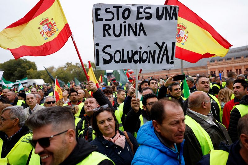 © Reuters. FILE PHOTO: Spanish truckers and farmers march to protest over working conditions and fair prices in Madrid, Spain, November 14,2022. The placard reads 