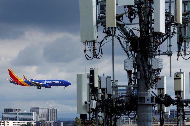 © Reuters. FILE PHOTO: A Southwest commercial aircraft flies near a cell phone tower as it approaches to land at John Wayne Airport in Santa Ana, California U.S. January 18, 2022 .  REUTERS/Mike Blake/File Photo