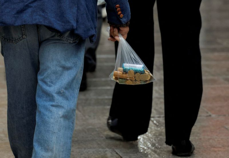 © Reuters. A man carries a plastic bag with new Euro coins in a street in Ronda, Spain, November 15, 2022. REUTERS/Jon Nazca