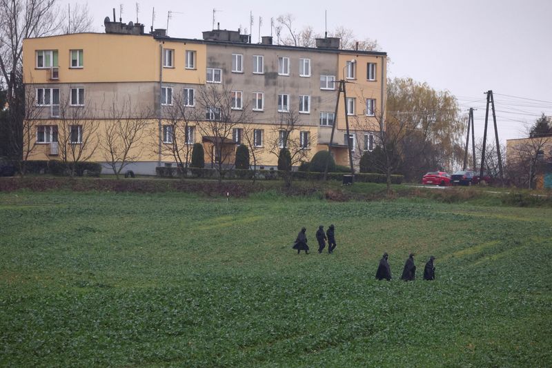 &copy; Reuters. Des policiers marchent près du site de l'explosion d'un missile à Przewodow, un village de l'est de la Pologne près de la frontière avec l'Ukraine. /Photo prise le 16 novembre 2022/REUTERS/Kacper Pempel