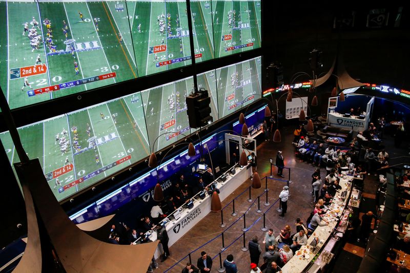 &copy; Reuters. FILE PHOTO: People make their bets at the FANDUEL sportsbook during the Super Bowl LIII in East Rutherford, New Jersey, U.S., February 3, 2019. REUTERS/Eduardo Munoz