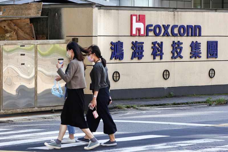 &copy; Reuters. FILE PHOTO: People walk past the logo of Foxconn outside the company's building in Taipei, Taiwan November 9, 2022. REUTERS/Ann Wang