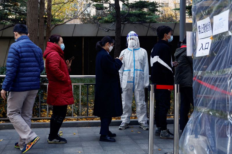 &copy; Reuters. FILE PHOTO: People line up to take a nucleic acid test for the coronavirus disease (COVID-19) at a testing booth near an office building in Central Business District (CBD) in Chaoyang district, Beijing, China November 15, 2022. REUTERS/Tingshu Wang/File P