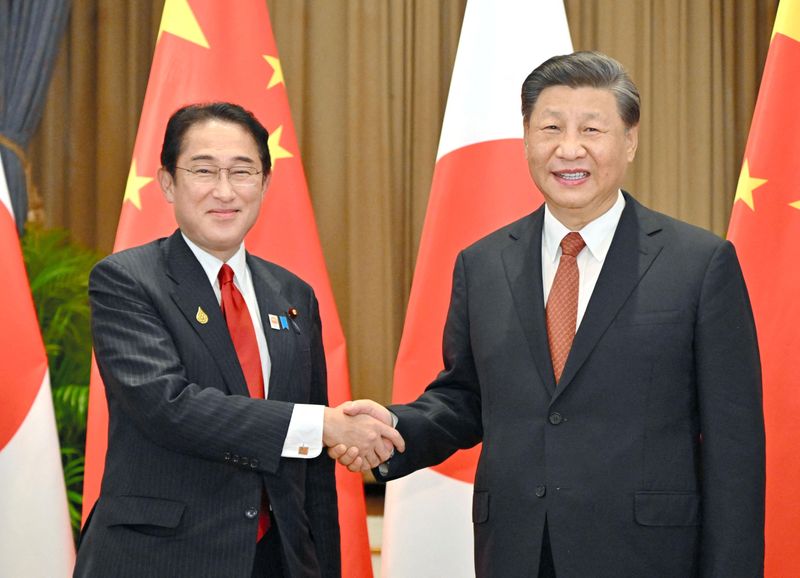 &copy; Reuters. الرئيس الصيني شي جين بينج (إلى اليمين) يصافح رئيس الوزراء الياباني فوميو كيشيدا في بانكوك يوم الخميس. صورة من وكالة كيودو للأنباء. 