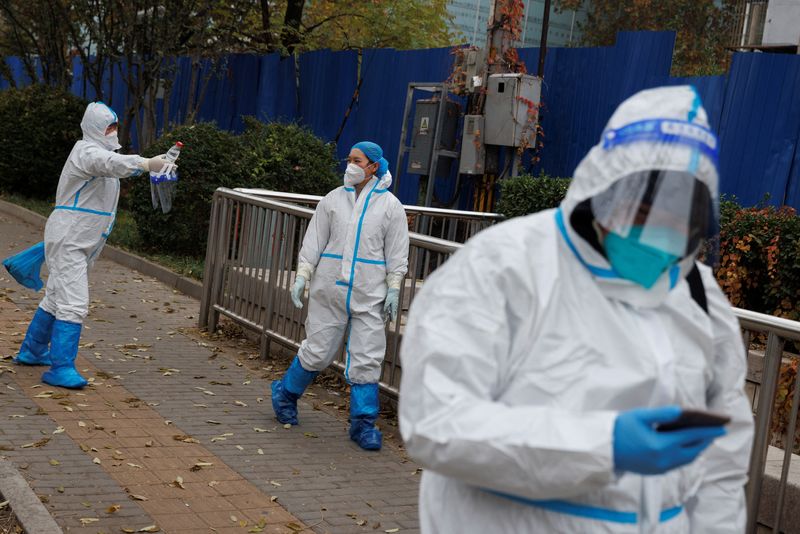 &copy; Reuters. Trabajadores de prevención de pandemias con trajes protectores caminan fuera de un complejo residencial cerrado mientras continúan los brotes de la enfermedad coronavirus (COVID-19) en Pekín, China, 18 de noviembre de 2022. REUTERS/Thomas Peter