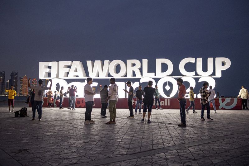 &copy; Reuters. أفراد يلتقطون صورا عند لافتة مضيئة لكأس العالم 2022 في الدوحة يوم الخميس. تصوير: ماركو ديوريتسا - رويترز.