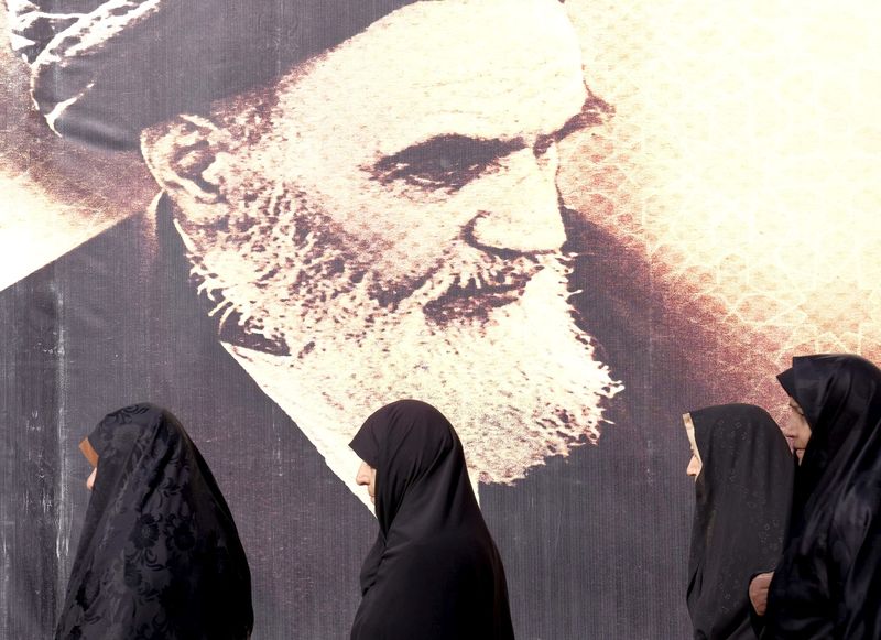 © Reuters. FILE PHOTO: Iranian women walk past a poster of Iran's late leader Ayatollah Ruhollah Khomeini during the anniversary ceremony of Iran's Islamic Revolution in Behesht Zahra cemetery, south of Tehran, February 1, 2016. REUTERS/Raheb Homavandi/TIMA
