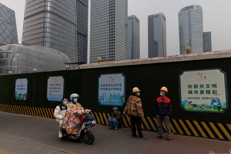 &copy; Reuters. عمال يضعون كمامات في المنطقة التجارية في بكين يوم التاسع من نوفمبر تشرين الثاني 2022. تصوير: توماس بيتر - رويترز