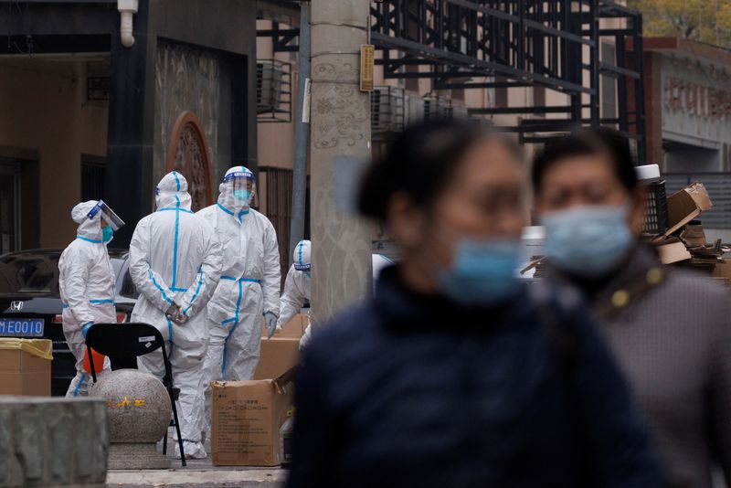 &copy; Reuters. مواطنون يسيرون في منطقة سكنية تخضع لإغلاق للحد من انتشار فيروس كورونا في بكين يوم 18 نوفمبر تشرين الثاني 2022. تصوير: توماس بيتر - رويترز.