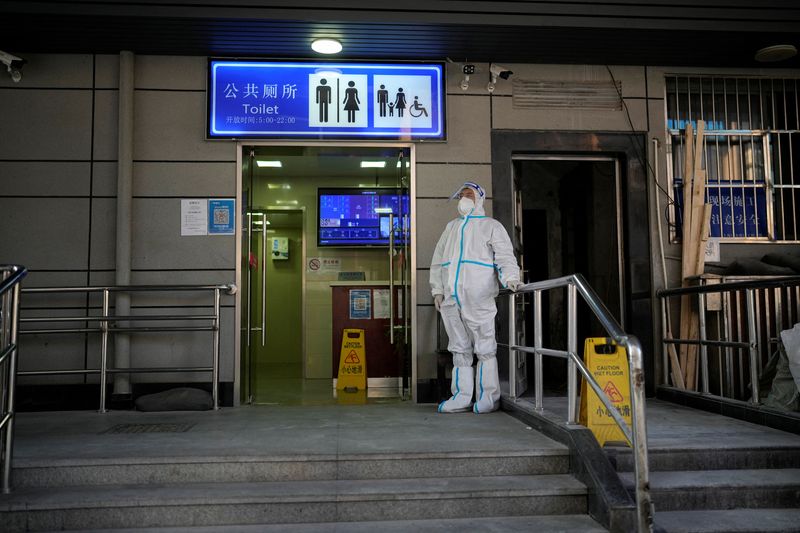 &copy; Reuters. Un travailleur en combinaison de protection surveille l'extérieur de toilettes publiques à Shanghai, en Chine. /Photo prise le 21 novembre 2022/REUTERS/Aly Song