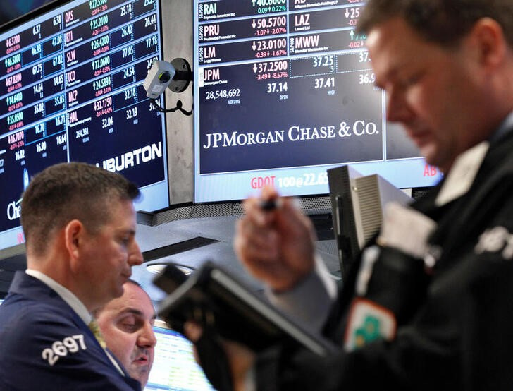&copy; Reuters. Imagen de archivo de opradores junto a una pantalla con el nombre de JP Morgan en la Bolsa de Nueva York, EEUU.