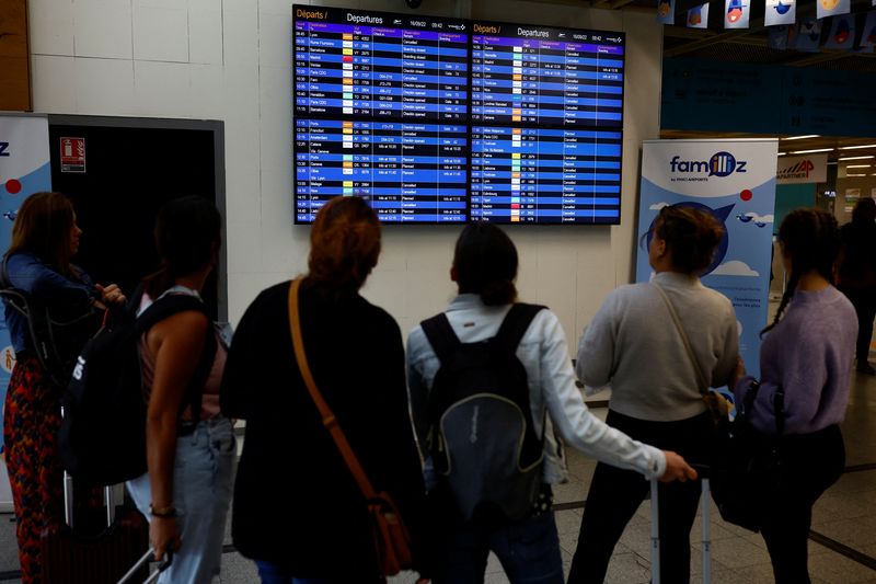 &copy; Reuters. FILE PHOTO: Travellers look at a flight departure screen displaying a series of flight cancellations during an air traffic controller's strike at the Nantes Atlantique airport in Bouguenais near Nantes, France, September 16, 2022. REUTERS/Stephane Mahe/Fi