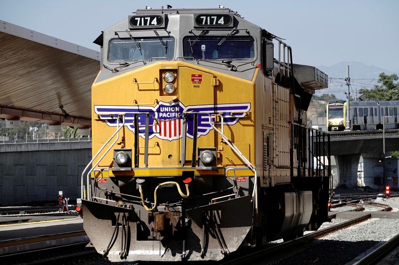 © Reuters. FILE PHOTO: A GE AC4400CW diesel-electric locomotive in Union Pacific livery, is seen ahead of a possible strike if there is no deal with the rail worker unions, as a Metrolink commuter train (right) arrives at Union Station in Los Angeles, California, U.S., September 15, 2022. REUTERS/Bing Guan/File Photo