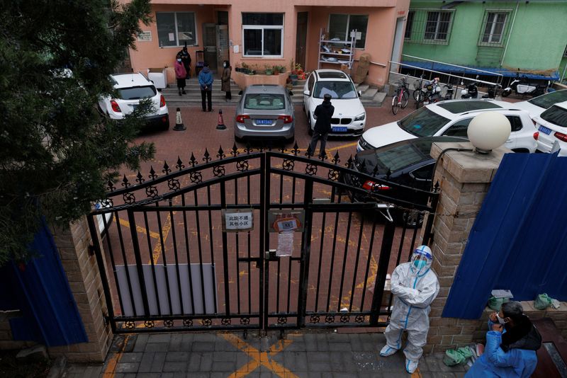 &copy; Reuters. A pandemic prevention worker in a protective suit keeps watch at at residential compound after it was locked down as outbreaks of coronavirus disease (COVID-19) continue in Beijing, November 18, 2022. REUTERS/Thomas Peter