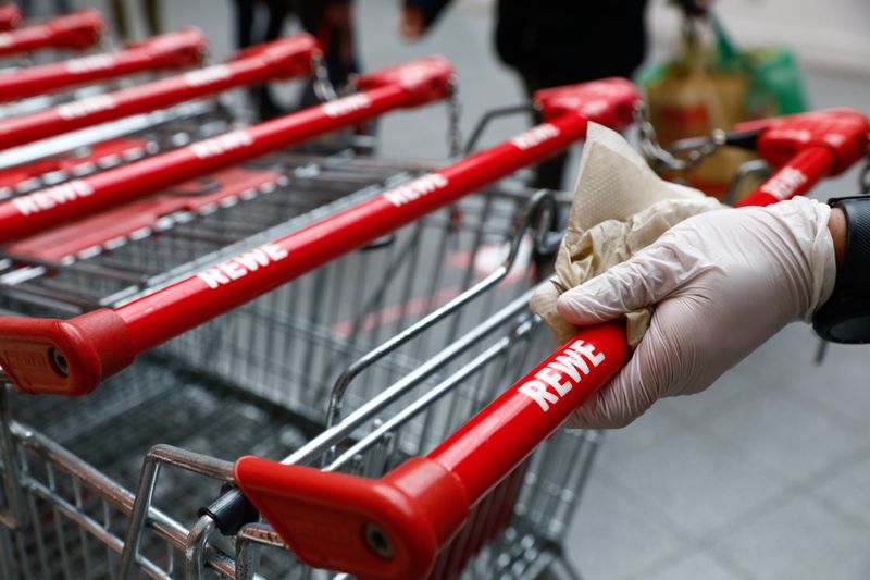 &copy; Reuters. FILE PHOTO: A staff member disinfects a shopping cart before each new customer at a Rewe grocery store in Potsdam, Germany, March 20, 2020, as the spread of the coronavirus disease (COVID-19) continues. REUTERS/Michele Tantussi/File Photo