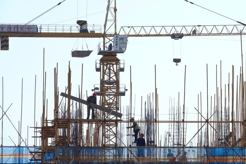 &copy; Reuters. FILE PHOTO: A Vanke sign is seen above workers working at the construction site of a residential building in Dalian, Liaoning province, China September 16, 2019. REUTERS/Stringer 