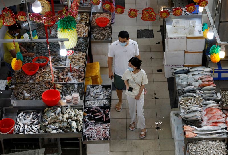 &copy; Reuters. FILE PHOTO: People shop for fish at a wet market during the coronavirus disease (COVID-19) outbreak, in Singapore September 21, 2021. REUTERS/Edgar Su