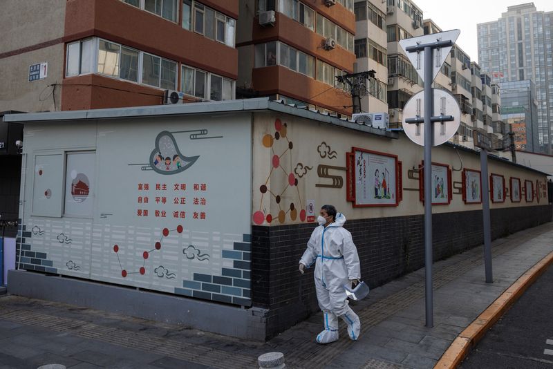 &copy; Reuters. An epidemic prevention worker in a protective suit walks in a street as outbreaks of the coronavirus disease (COVID-19) continue in Beijing, China, November 23, 2022. REUTERS/Thomas Peter