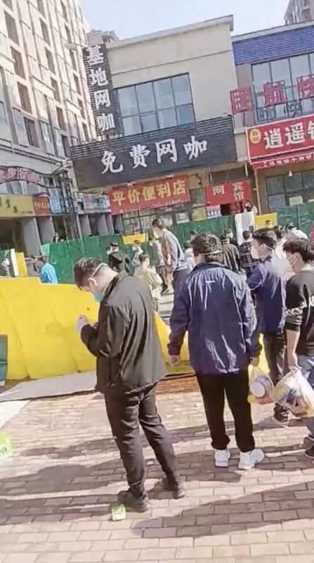 &copy; Reuters. Un grupo de personas cruza una valla derribada tras una protesta en la planta de Foxconn en Zhengzhou, China, en esta captura obtenida de un vídeo publicado el 23 de noviembre de 2022. Vídeo obtenido por Reuters/vía REUTERS   