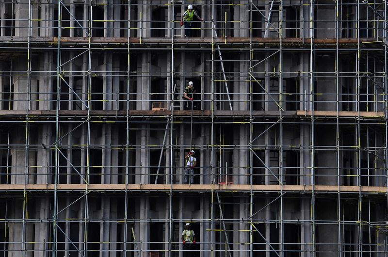 &copy; Reuters. FILE PHOTO: Scaffolders work on a construction site in London, Britain, October 20, 2021. REUTERS/Toby Melville