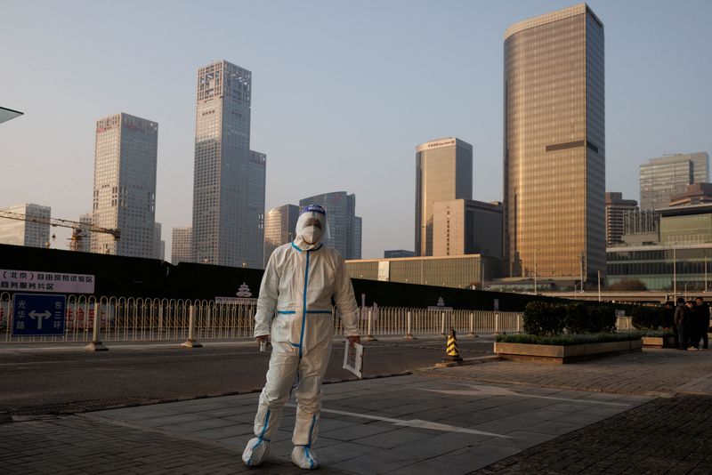&copy; Reuters. Un trabajador de prevención de epidemias con traje de protección vigila la entrada de un edificio de oficinas en el Distrito Central de Negocios mientras continúan los brotes de la enfermedad del coronavirus (COVID-19) en Pekín, China. 23 de noviembre