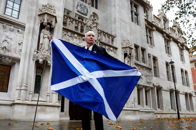 © Reuters. متظاهر مؤيد للاستقلال يحمل العلم الاسكتلندي أمام   المحكمة البريطانية العليا يوم الأربعاء أثناء نظرها طلب اسكتلندا بتنظيم استفتاء على الاستقلال العام المقبل. تصوير : بيتر نيكولز- رويترز .   