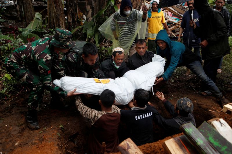 © Reuters. مجموعة من الأشخاص في مدينة سيانجور يدفنون جثة أحد ضحايا زلزال إندونيسيا يوم الأربعاء  بعد أن ضرب البلاد. تصوير : أجينج دينار أولفيانا- رويترز .  