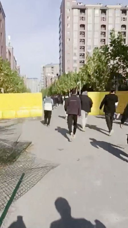 &copy; Reuters. Grupo de pessoas atravessa uma cerca derrubada após um protesto na fábrica da Foxconn, em Zhengzhou, China, em captura de tela obtida de um vídeo divulgado em 23/11/2022. Video obtido pela Reuters/via REUTERS