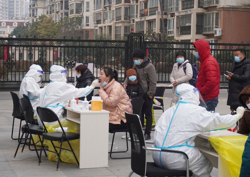 &copy; Reuters. Photo d'archives de résidents effectuant un test d'acide nucléique à Zhengzhou, dans la province du Henan, en Chine. /Photo prise le 4 janvier 2022/cnsphoto via REUTERS