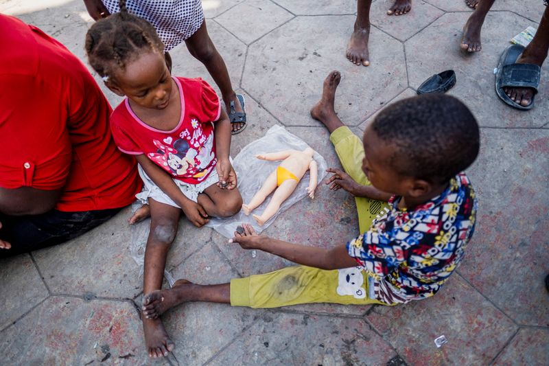 &copy; Reuters. FILE PHOTO: Children play with a broken doll at the Hugo Chavez Square where they shelter from gang war violence in Port-au-Prince, Haiti October 16, 2022. REUTERS/Ricardo Arduengo/File Photo