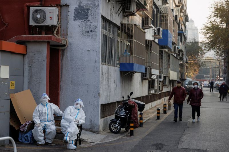 &copy; Reuters. Trabajadores de prevención de epidemias con trajes de protección sentados en un complejo residencial cerrado mientras continúan los brotes de la enfermedad del coronavirus (COVID-19) en Pekín, 23 de noviembre de 2022. REUTERS/Thomas Peter
