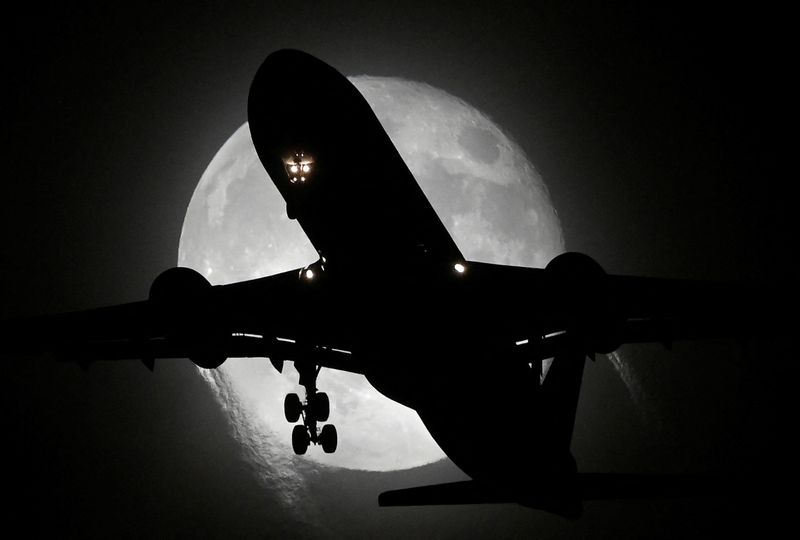 © Reuters. An aircraft passes in front of the moon as it makes its landing approach to Heathrow Airport in London, Britain, November 9, 2022. REUTERS/Toby Melville