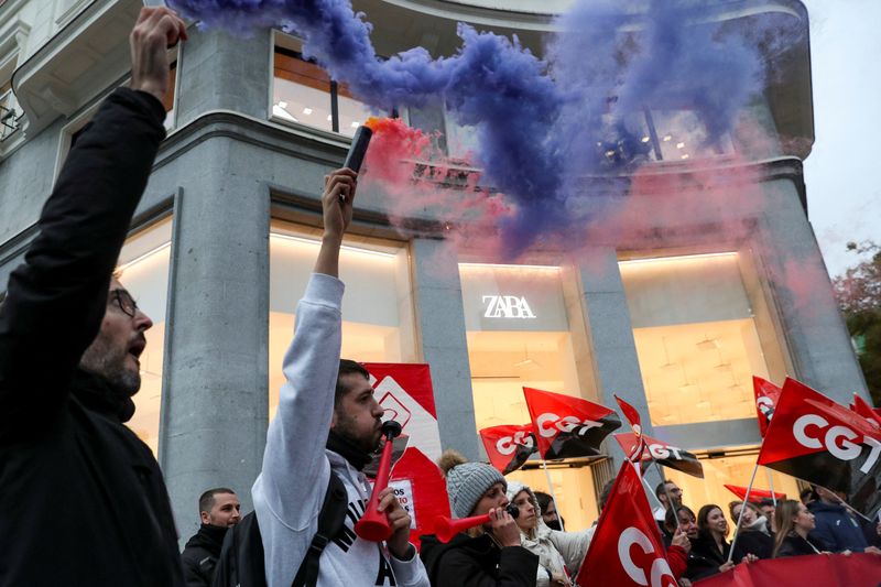 &copy; Reuters. Des personnes tiennent des drapeaux du syndicat espagnol CGT lors d'une manifestation devant un magasin de vêtements Zara à Madrid, Espagne. /Photo prise le 24 novembre 2022/REUTERS/Violeta Santos Moura