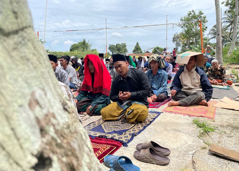 Indonesians pray outdoors after deadly quake destroys town